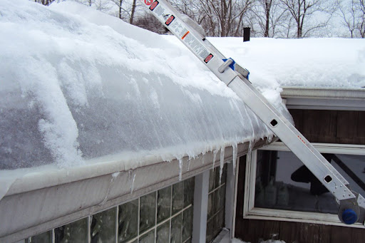 Ladder against a snowy roof before tackling ice dam prevention