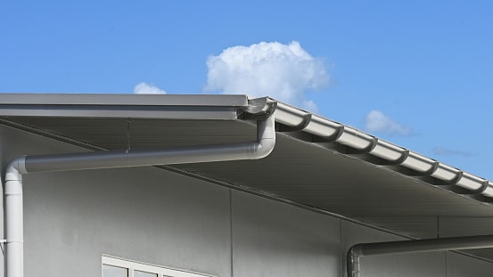 Half Round Steel Roof Gutter And Downpipe On A Commercial Building