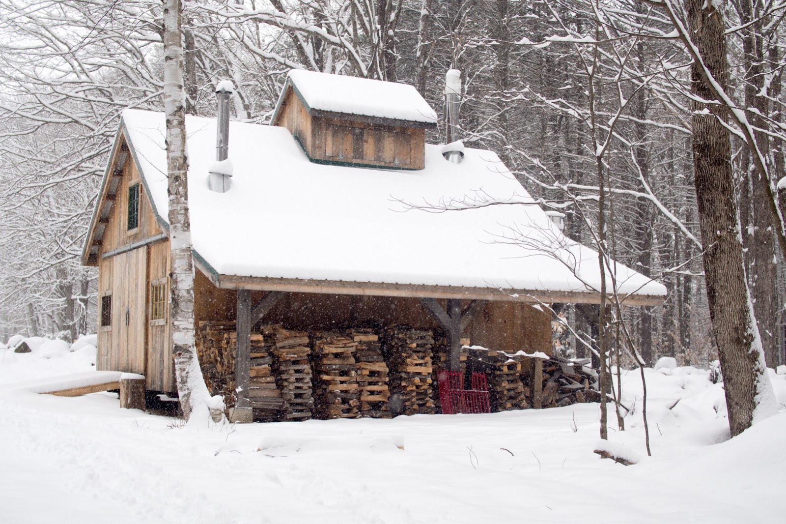 A rustic cabin covered in snow