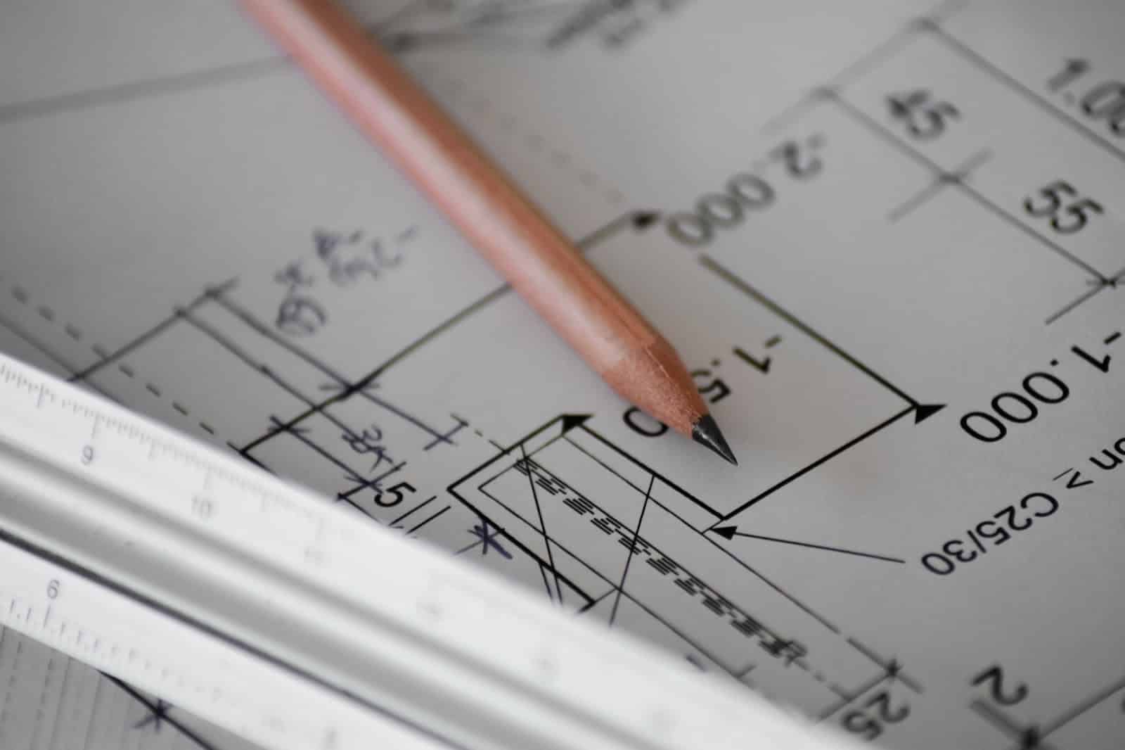 Close-up of building plans with pencil and ruler