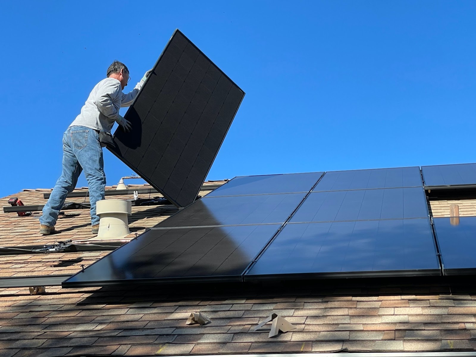 Solar panels being installed on a shingle roof
