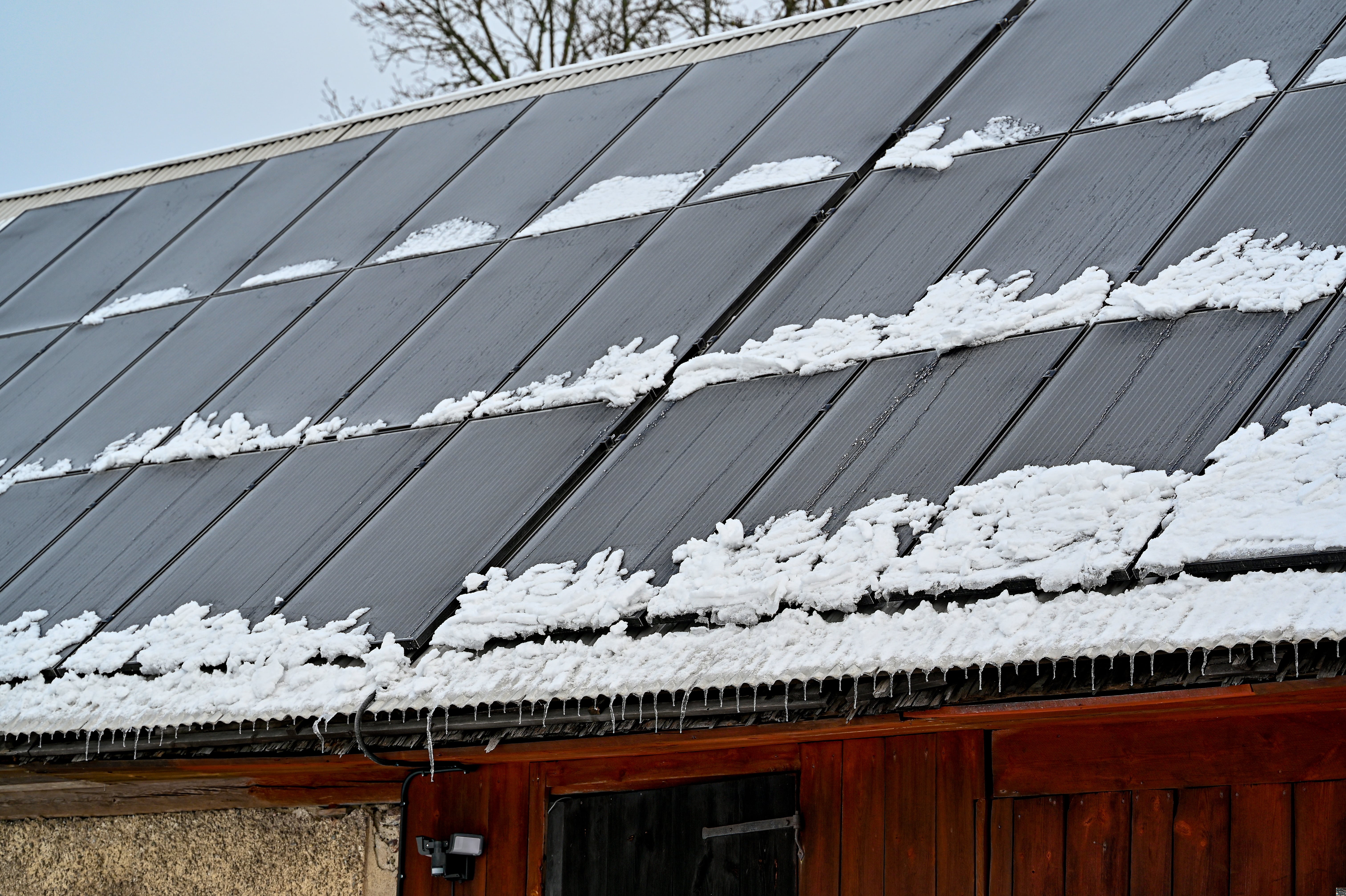 Winter roof with solar panels and light snow