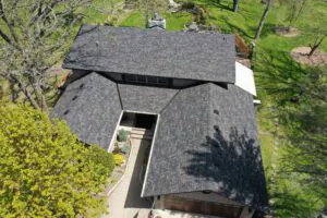 Home with a U shaped design that features a dark roof
