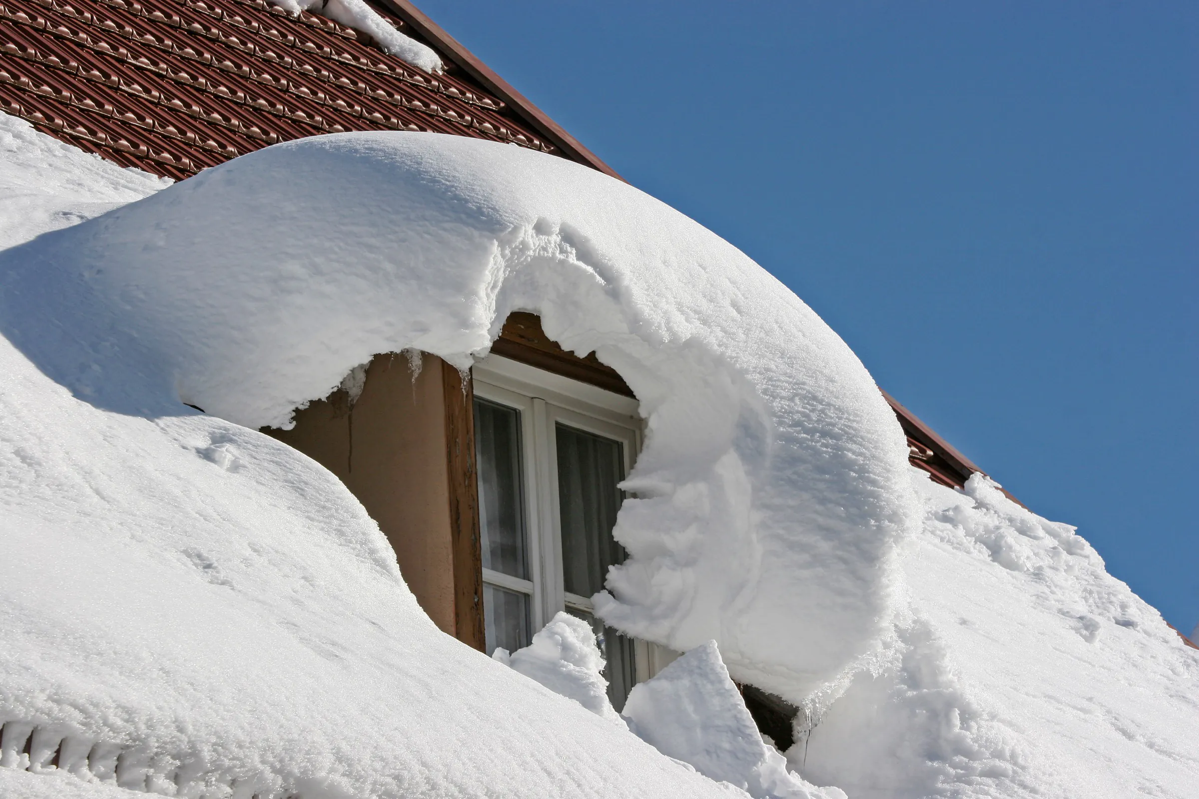 Snow piling atop a home's roof during winter