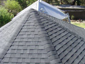 The peak of a semi-circular shingle roof