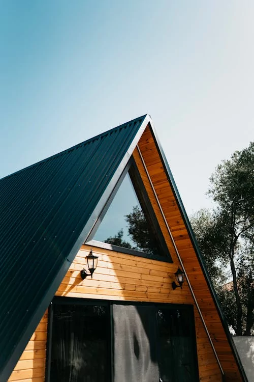 Metal roof on a wooden A-frame home that features steep roofing