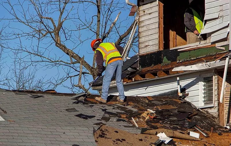 Roofer making repairs to a damaged rooftop