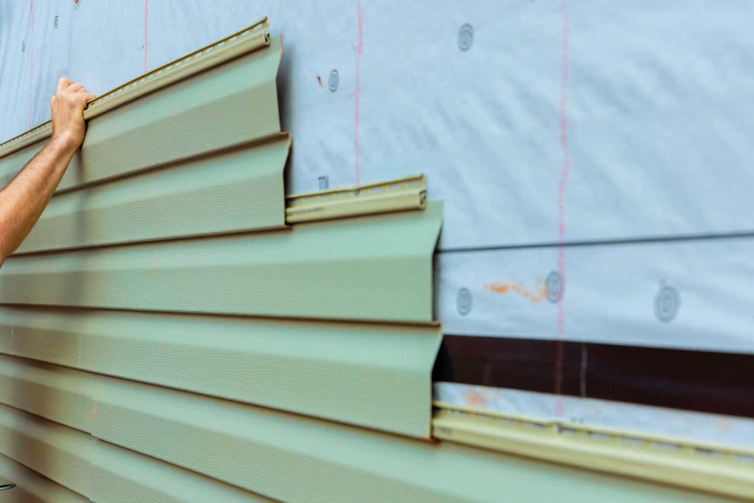 worker installing green siding on a house exterior 2025 01 21 14 16 50 utc