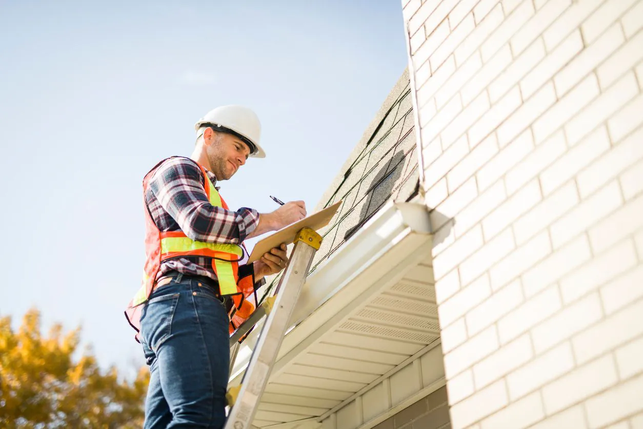 A contractor inspecting a home's roof during a routine inspection in Minnesota